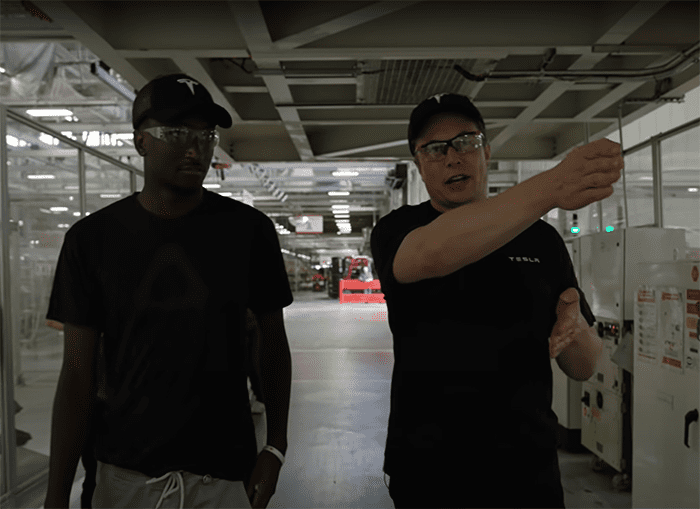 Two men standing in a factory or warehouse setting.