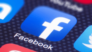 A blue square Facebook logo with a white "f" on a gray background with small white dots.