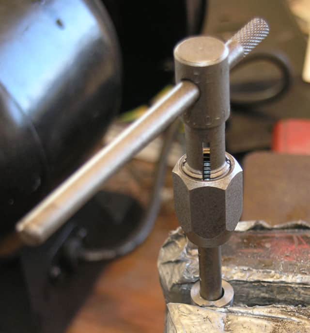 Close-up view of a metalworking tool with cylindrical shape, small holes and ridges.