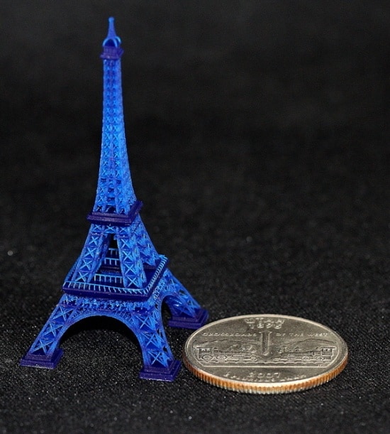 The eiffel tower is next to a dime.