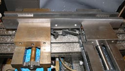 Metal workbench with metal vise and blue object inside.