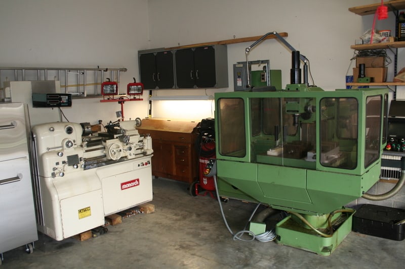 A well-equipped home workshop with a lathe, router, and other machinery.
