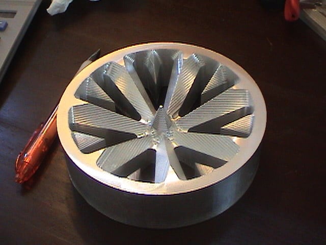 Circular metal wagon wheel with central hole and radiating ridges.
