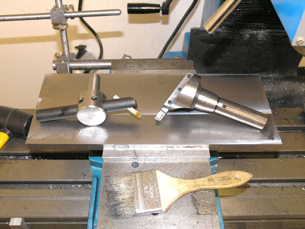 Metalworking vise on workbench with T-shaped bar and tools in place.