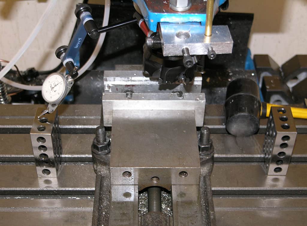 Machine shop workbench with vise, clamps, and measuring instruments.