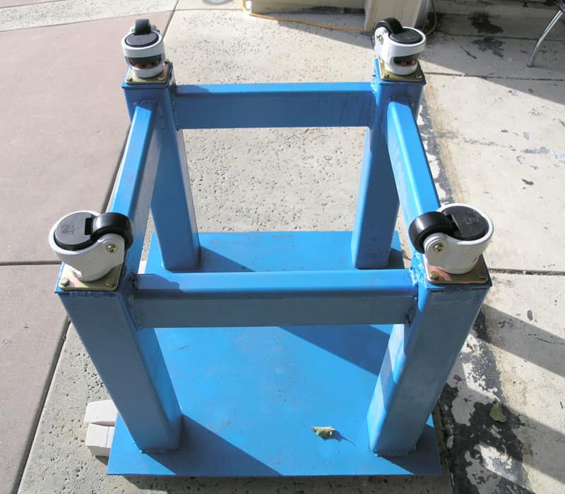 Blue metal frame with four wheels on a rectangular base.