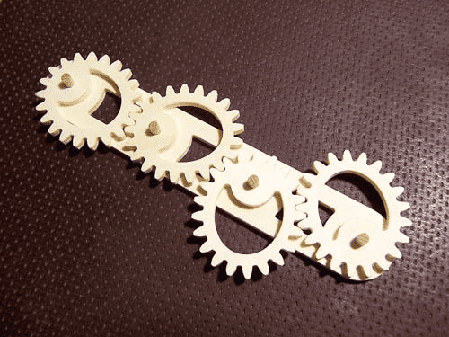 A set of CNC-machined gears on a black surface, created using advanced gear design software.