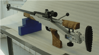 Metalworking vise with long bar attached on a table.