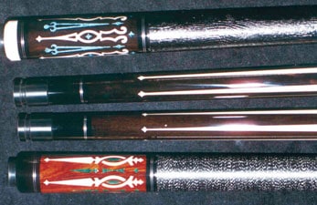 Three pool cues with different designs on them.