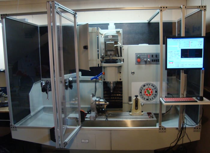 A metalworking machine with control panel and display screen in a workshop.