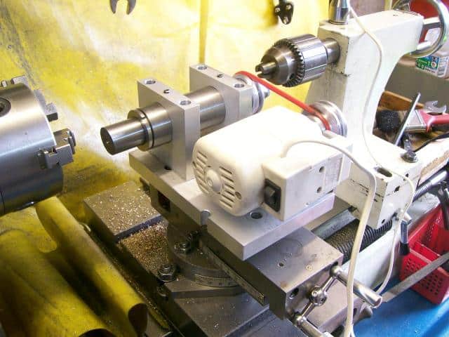 A lathe in an industrial setting on a yellow background.