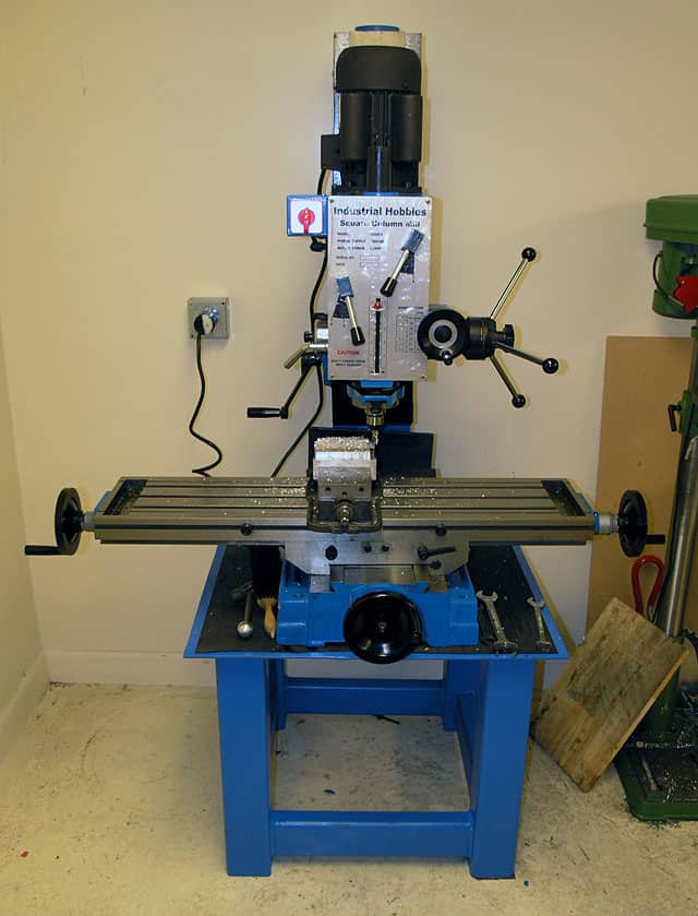 Milling machine in workshop setting with Industrial Hobbies label and surrounding tools and equipment.