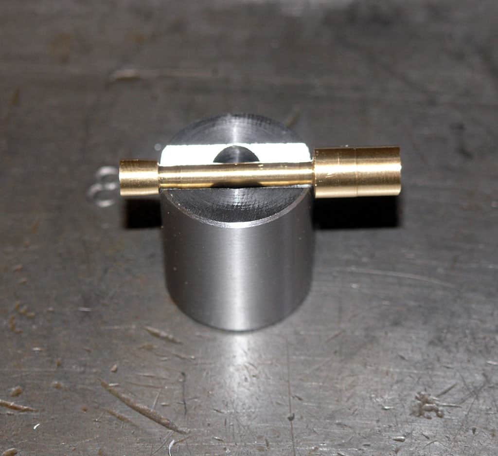 Small metal cylinder with two brass rods.