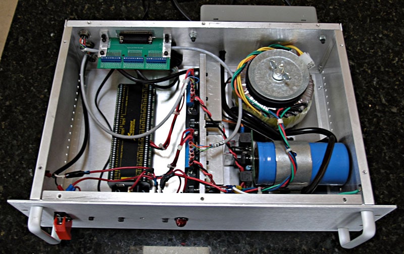 Metal box with electronics, wires, circuit boards, and a blue cylinder.