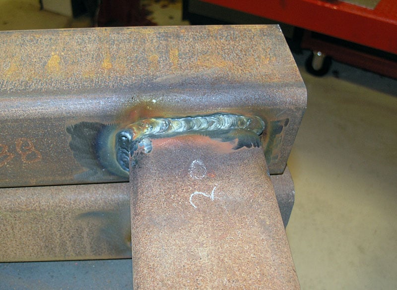Rusted steel or iron metal with welded joint and visible seam.