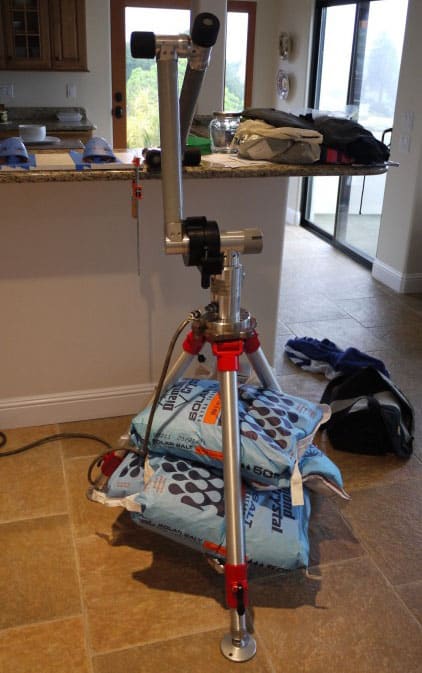 Metal tripod supporting stacked bags with sand-themed labels.