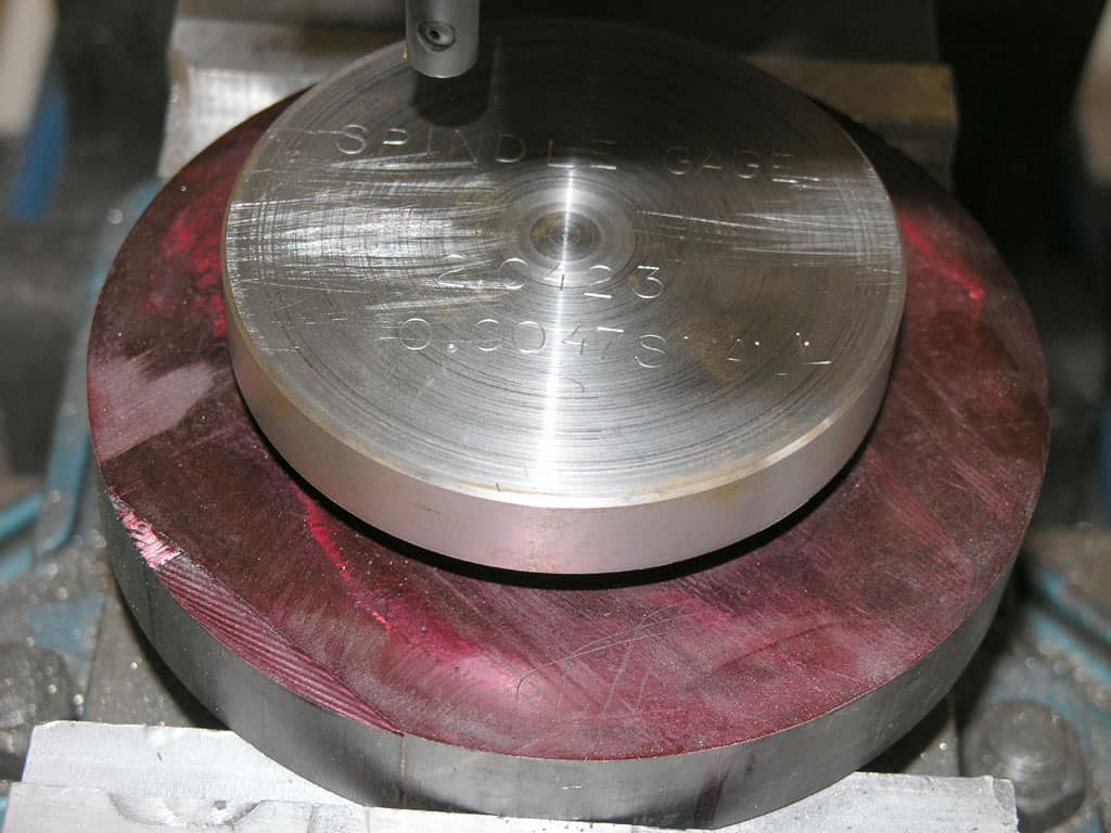 Circular metal gauge with engraved markings.
