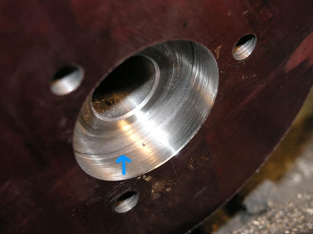Close-up shot of a silver-colored metal object with circular shape and two smaller holes on either side.