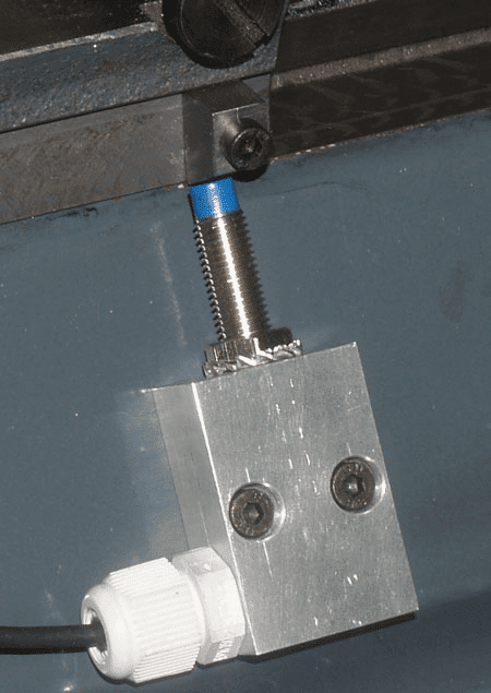 Metal component with blue cap and silver bolts.