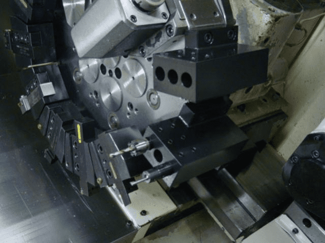 Complex metalworking machine part with intricate details and holes.