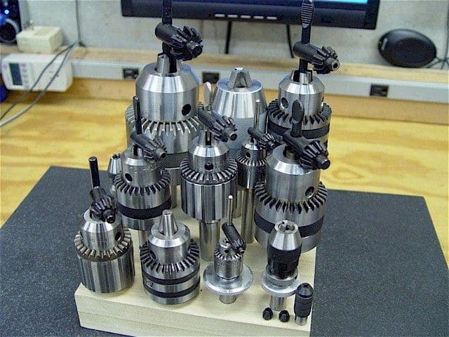Keyed drill chucks on a wooden base.