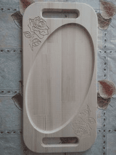 A rectangular wooden cutting board with carved rose design.