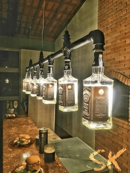 Repurposed whiskey bottle lighting fixture in an industrial setting.