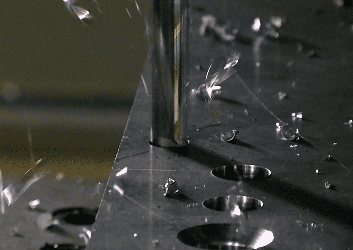Metal surface with circular holes and sparks.