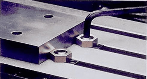 Metal plate with two holes and a nut and bolt.