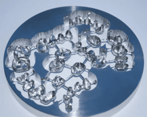 Circular metal product with reflective surface and small, rounded protrusions.