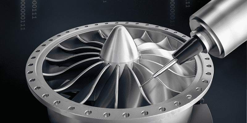 A silver metallic turbine component with central hub and radial blades, set against a dark background.