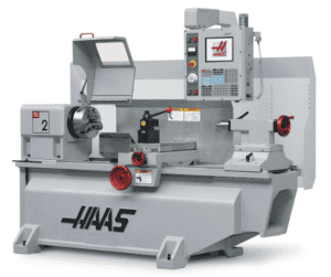 A large industrial Haas CNC machine with a gray body and red accents.